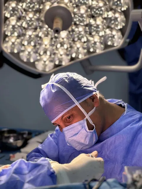 Portrait professionnel de chirurgien en tenue de bloc sous le scialytique