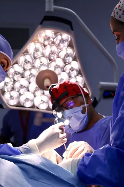 Surgical team mid-procedure under the operating light, operating theatre photo shoot